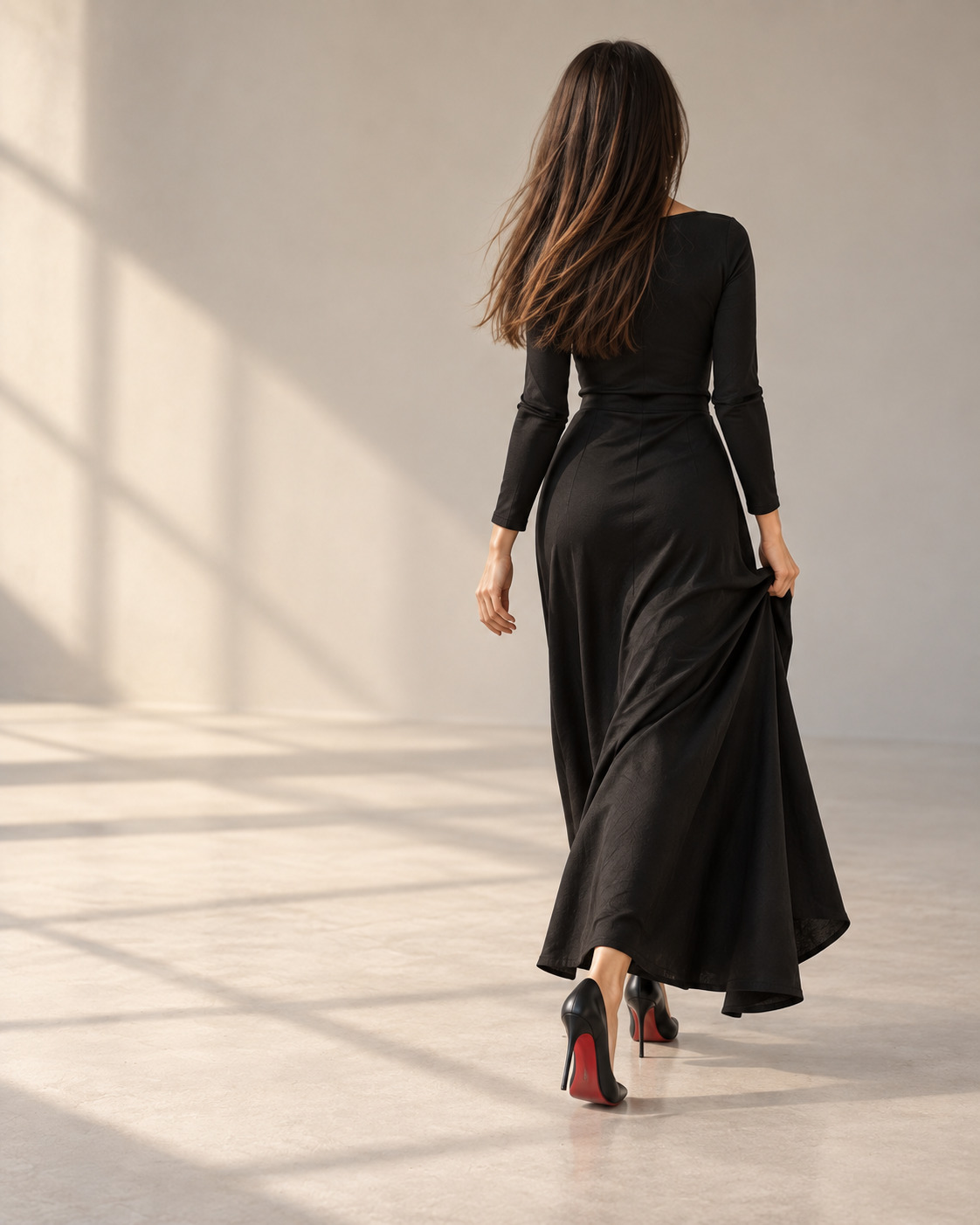Élise walking away across the studio in a black dress, with a glimpse of crimson shoe soles